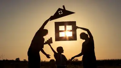 Foster family holding up a silhouette of a house cut out