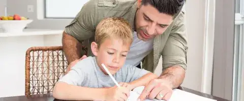 Foster father helping with a child to write