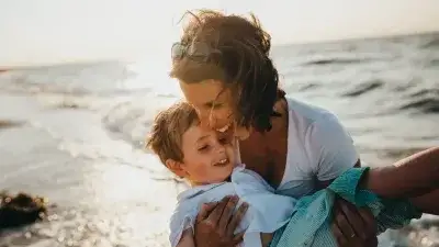 Foster mother and child on a beach in her arms
